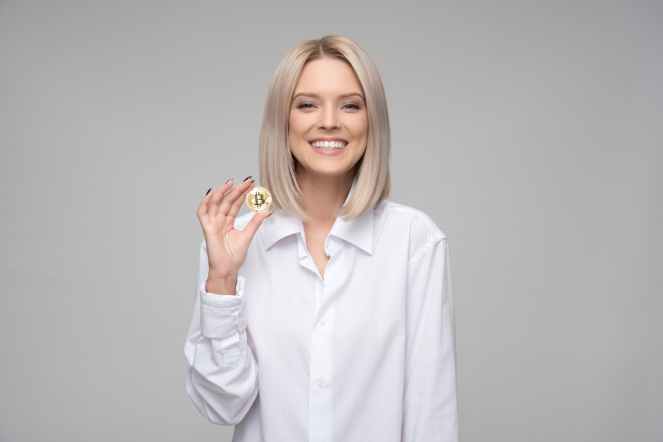 women wearing white long sleeved collared shirt holding bitcoin